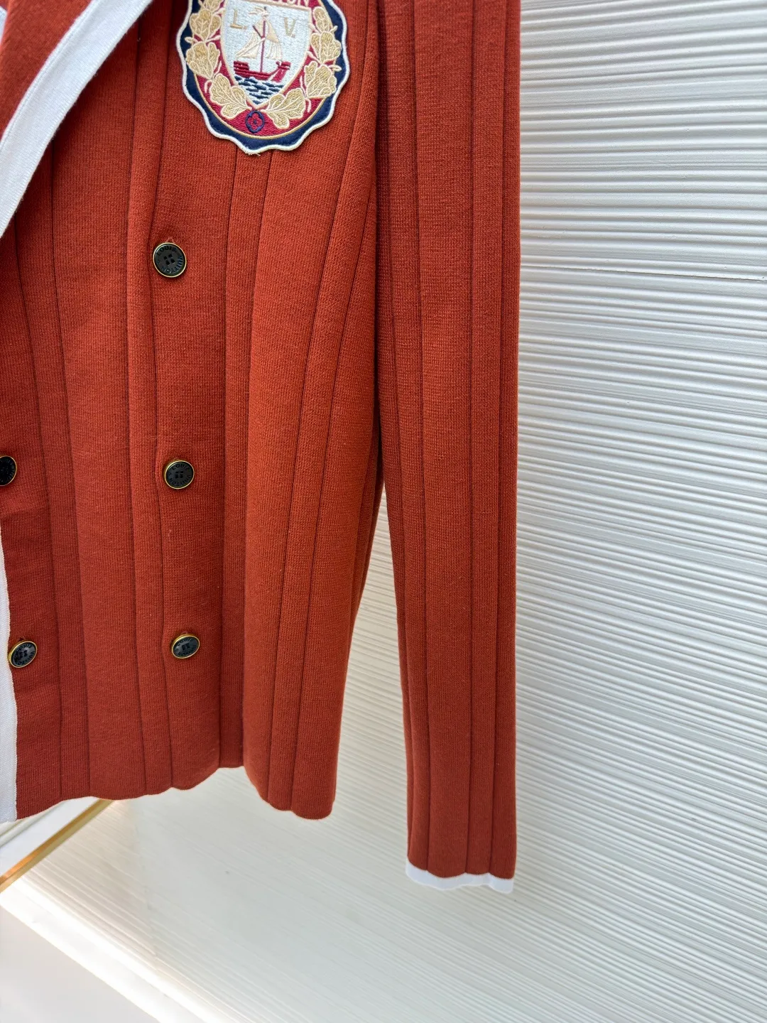 LOUIS VUITTON College style knitted cardigan ●Item number: 1682057-B95 ●Material: wool blended fabric ●Technology: knitted ●Color: red ●Version: fitted version ●Weight: about 755 grams ●Size: S-M-L-XL ●Description: This Louis Vuitton knitted cardigan is made of high-count wool blended fabric. It uses vertical pit strip knitting technology to create a delicate and crisp texture, which is both soft and supportive. The collar, placket and cuffs use contrasting piping technology, with white webbing and caramel brown main body forming a visual hierarchy. The edges are reinforced with overlocking to improve wearability. The double-breasted design on the front uses metallic resin buttons, echoing the three-dimensional badge on the body. The badge uses embroidery + patching composite technology to precisely sew the brand logo and decorative elements. The color transition is natural and not easy to fall off. The overall shape is optimized through diagonal side seam splicing, which not only retains the looseness of knitting, but also enhances the sharpness of the lines. It is a combination of craftsmanship and design. The overall wiring is straight and delicate, the fabric is comfortable and soft, and the color is consistent without color difference. It can be matched with the same style to create a fashionable look and control various occasions. Customized accessories, complete with three standards, same style for men and women!
